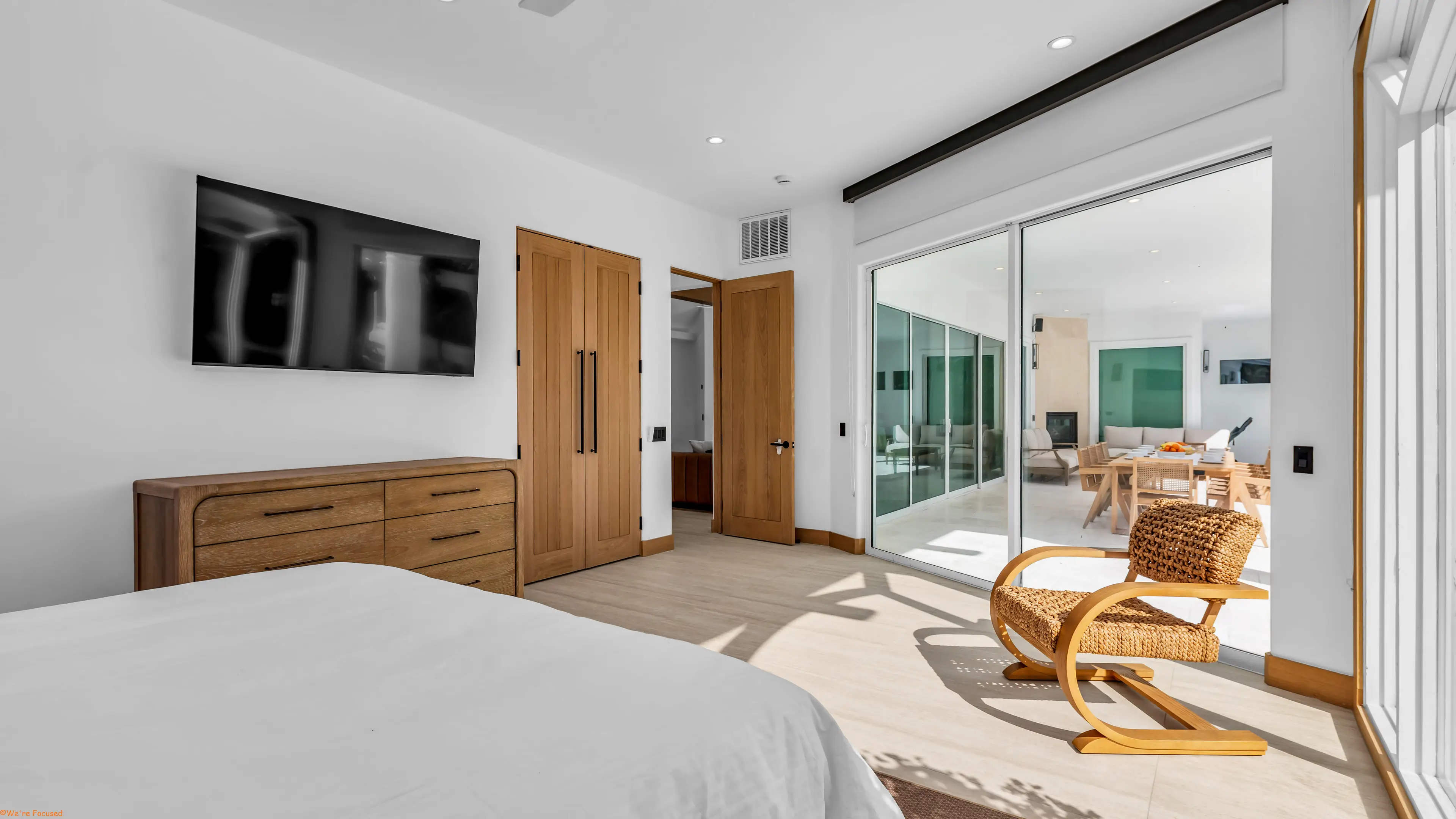 Bedroom with an oak dresser and sliding doors onto the covered terrace.