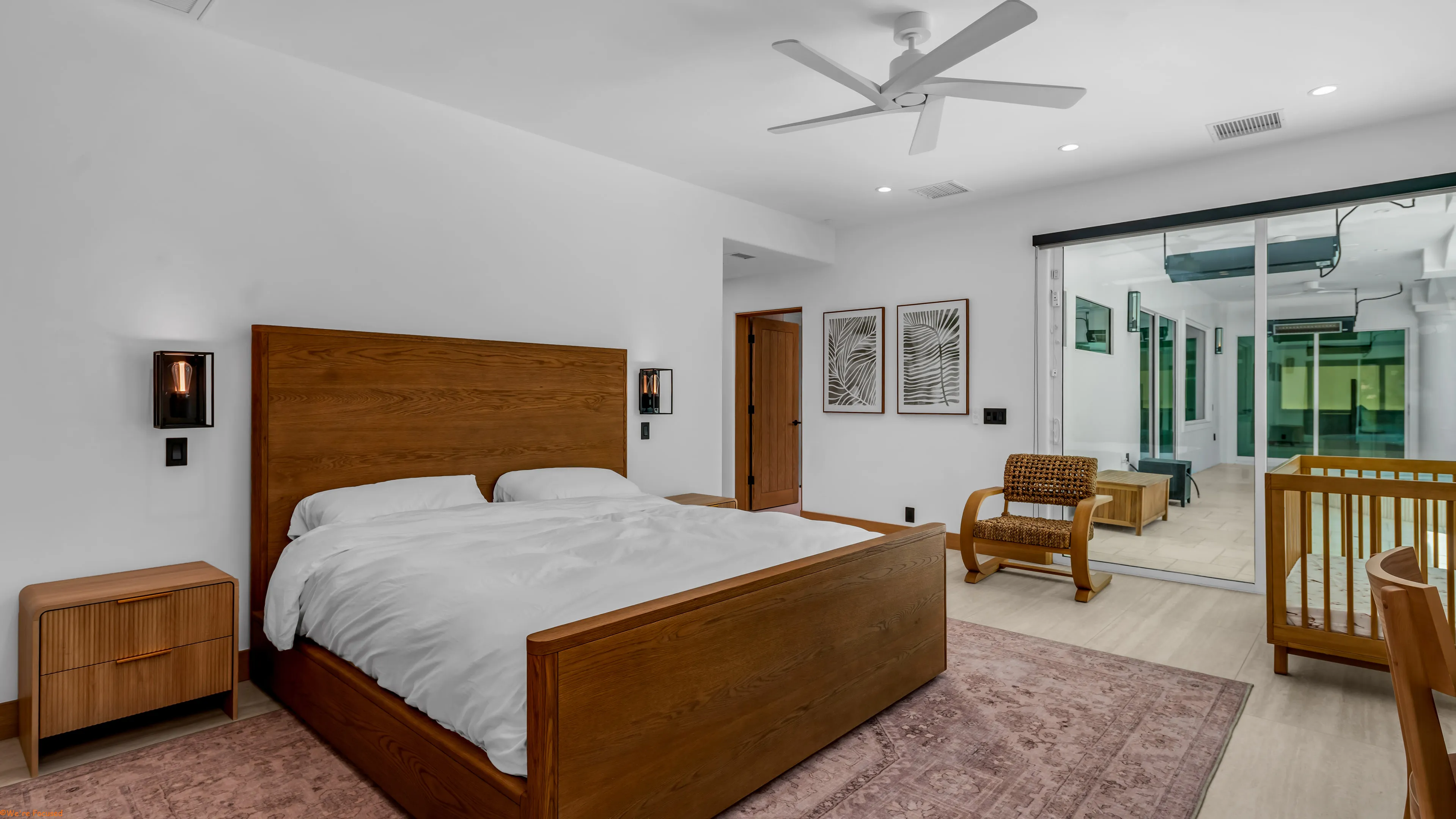 Bedroom with a solid wood bed frame and glass doors onto the covered terrace.