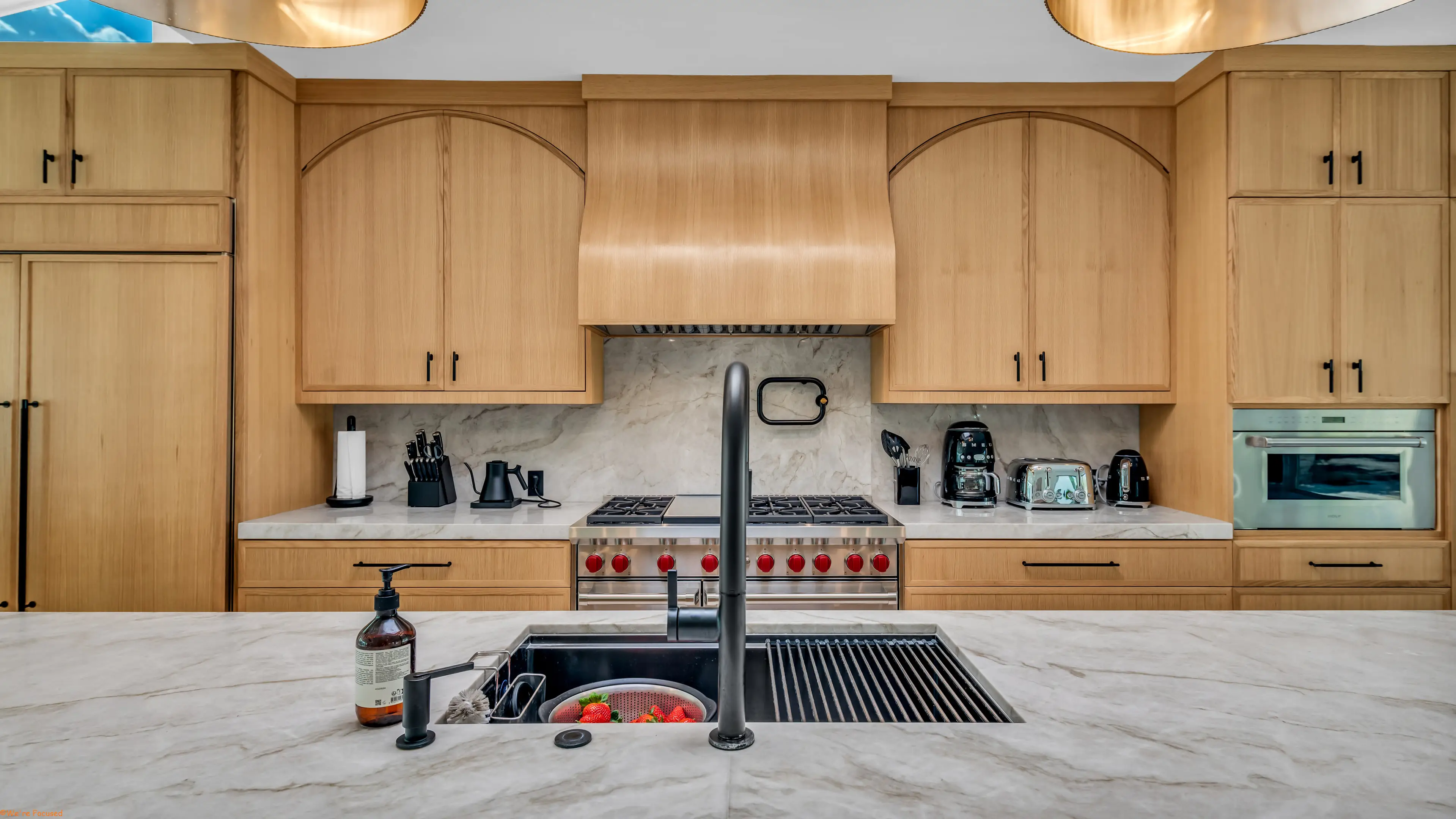 The range and marble backsplash with a black tap over the sink.