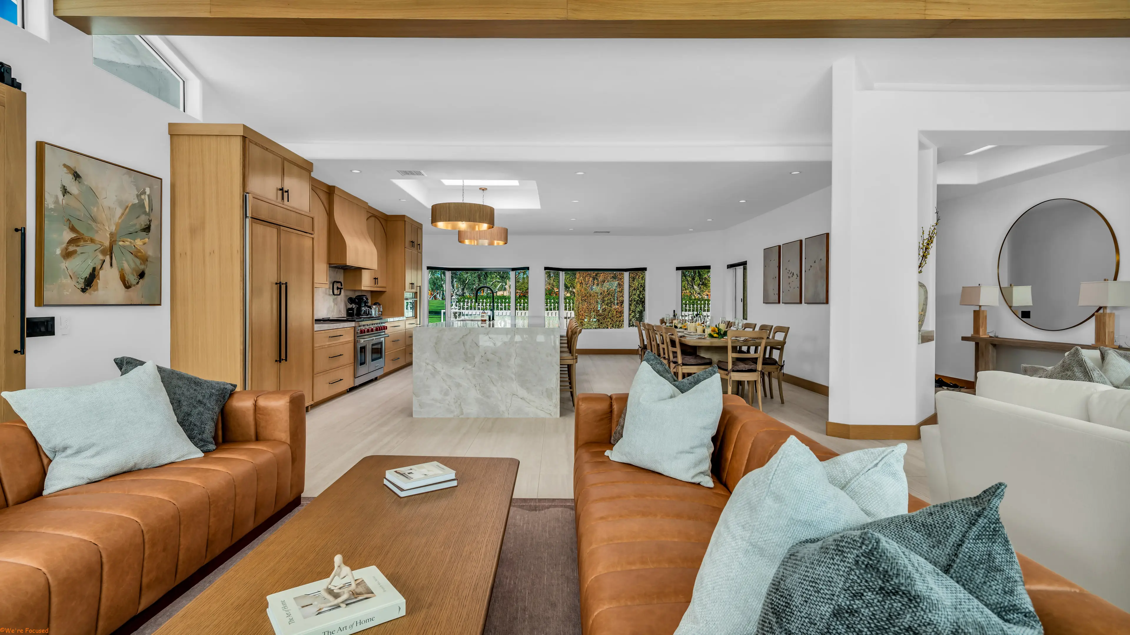 The living room seen from the kitchen, with the dining table and terrace beyond.
