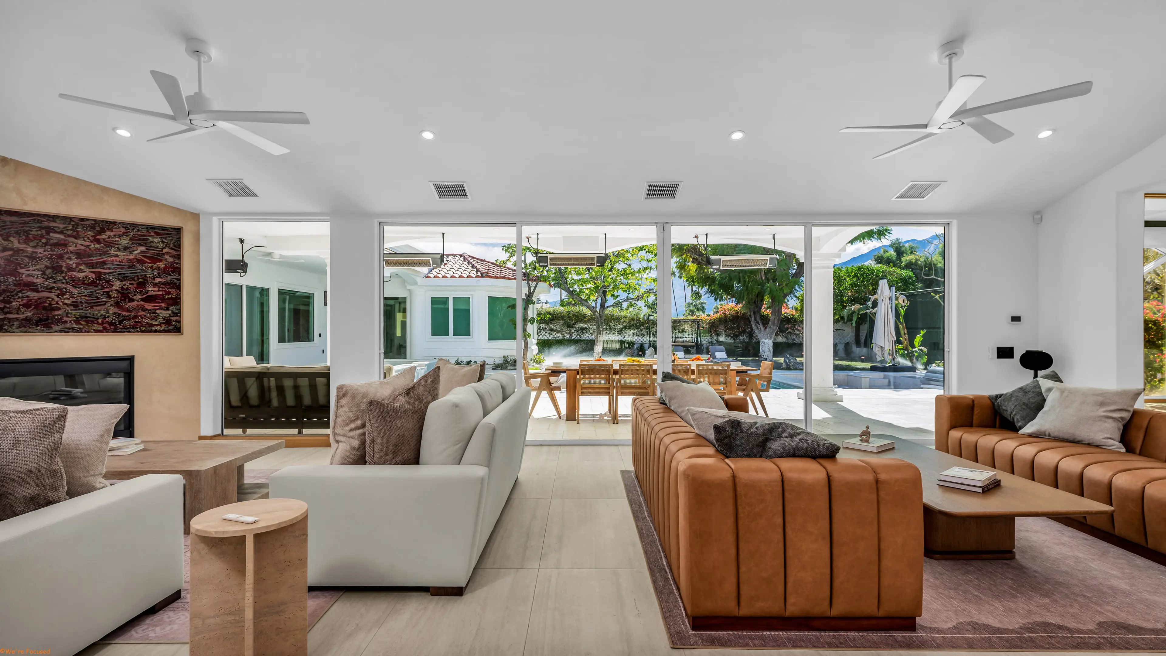 Living room seating with the terrace and pool visible through the open glass wall.