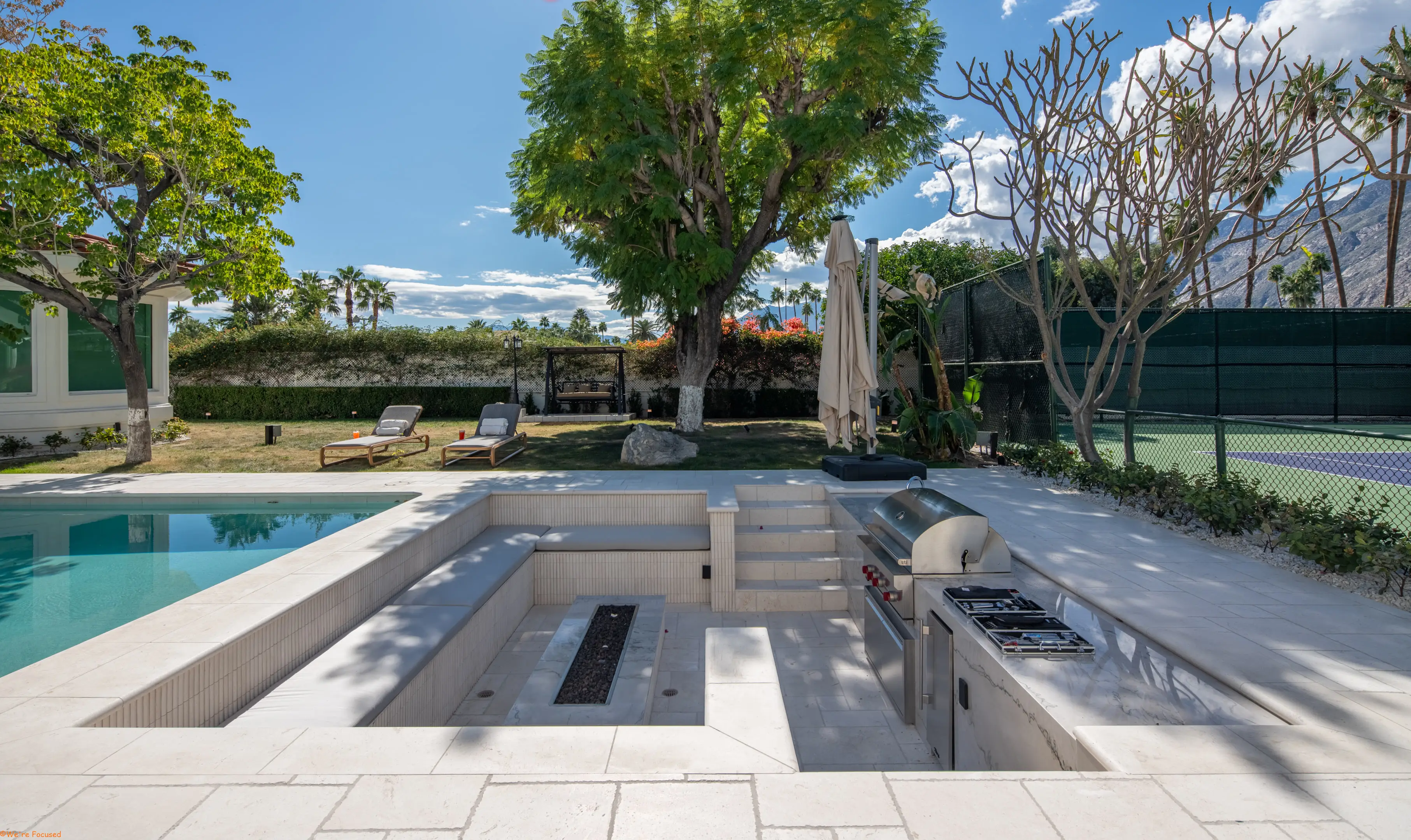 The sunken fire pit and the built in barbecue set below the level of the terrace.