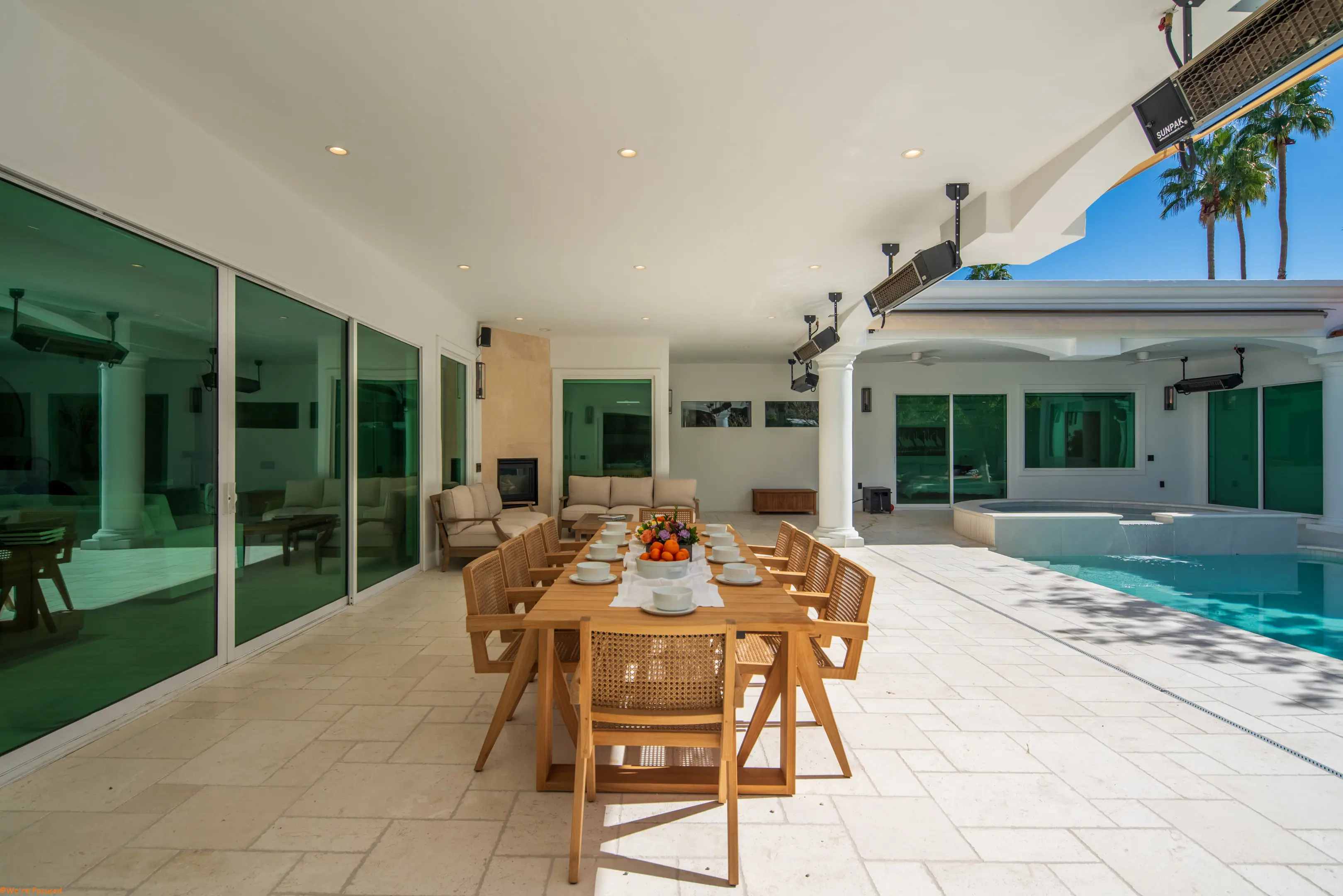 The long outdoor table under the colonnade with the pool alongside.