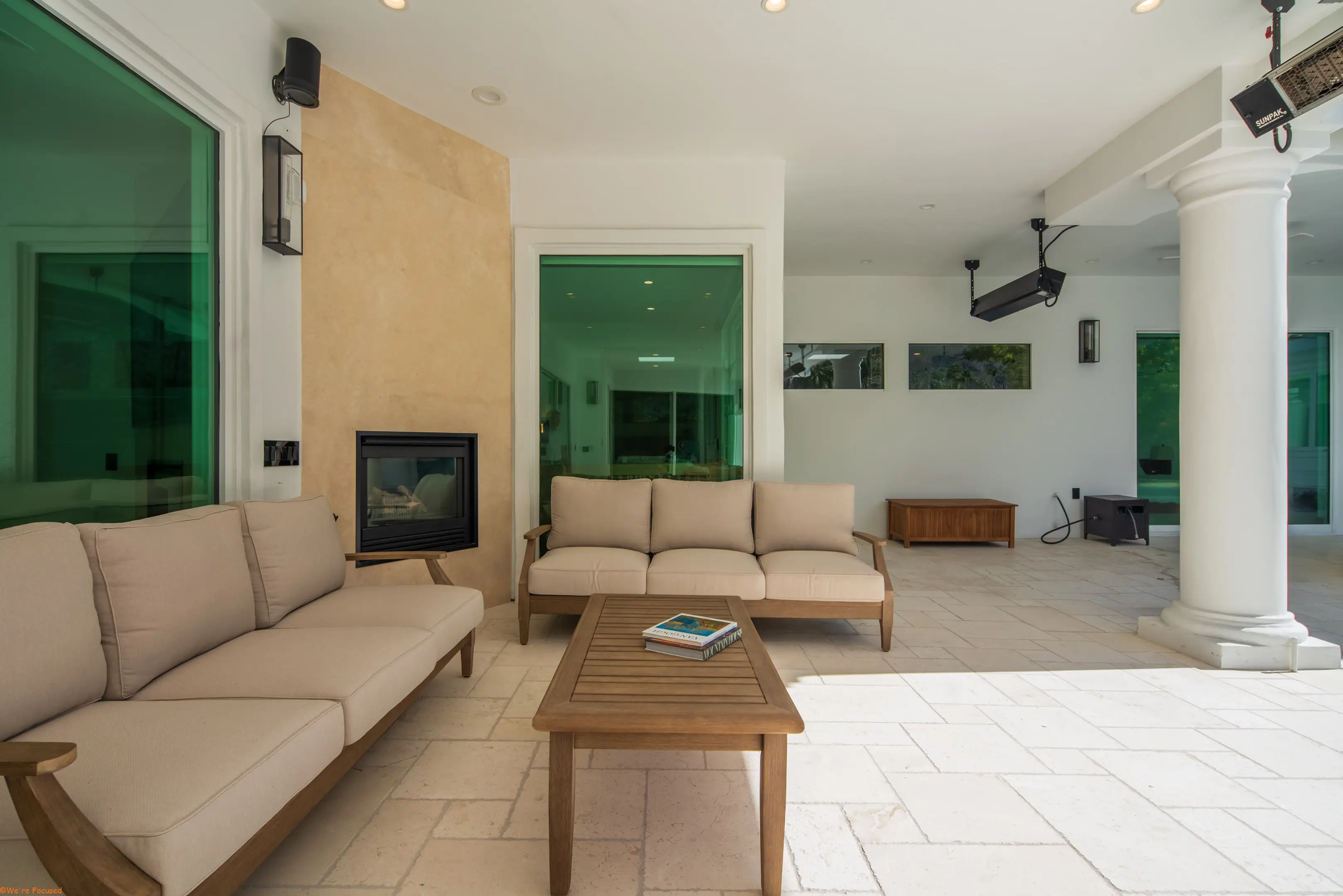 Teak seating under the colonnade beside the outdoor fireplace.