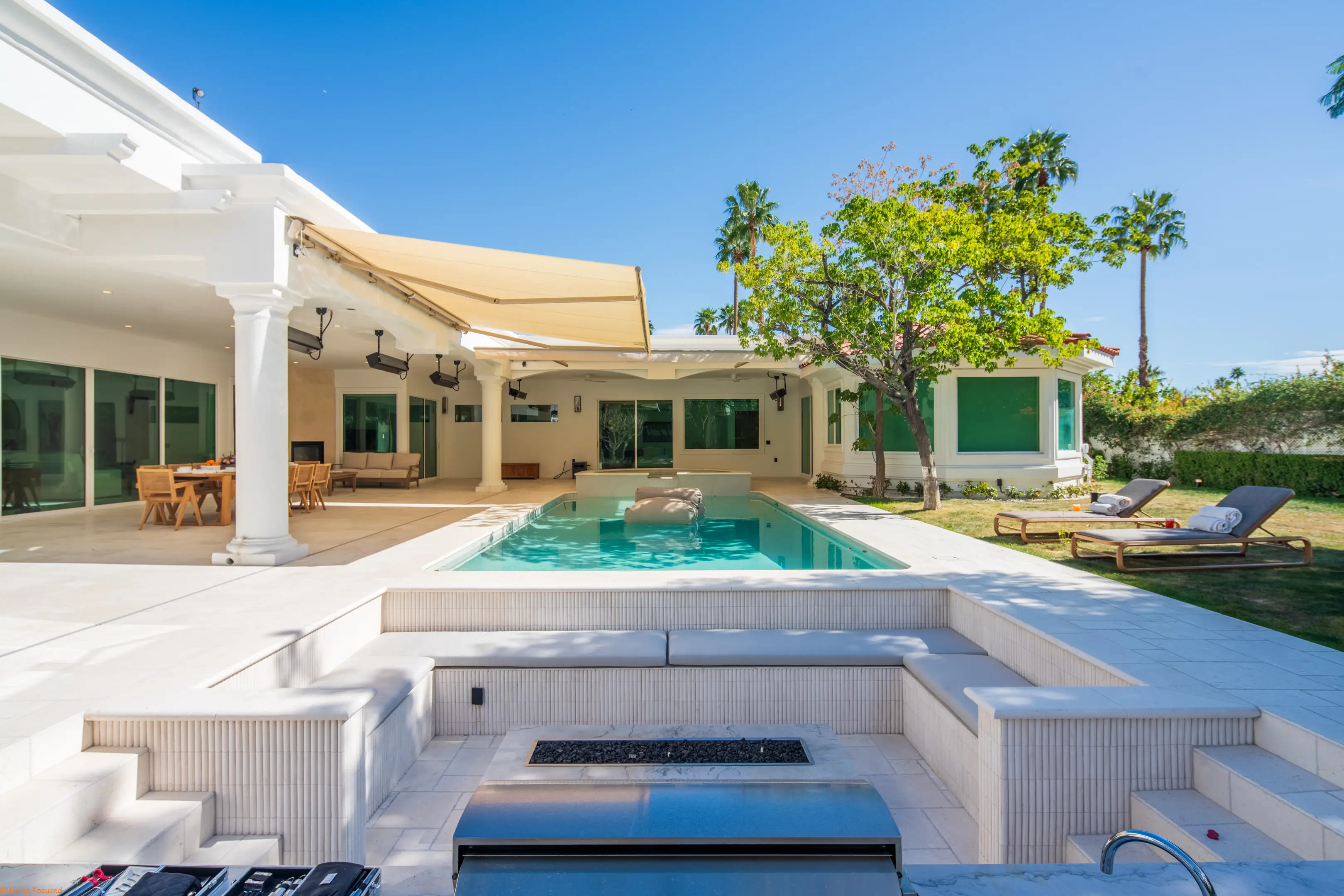 The courtyard with the pool, the fire pit and the retractable awning above the terrace.