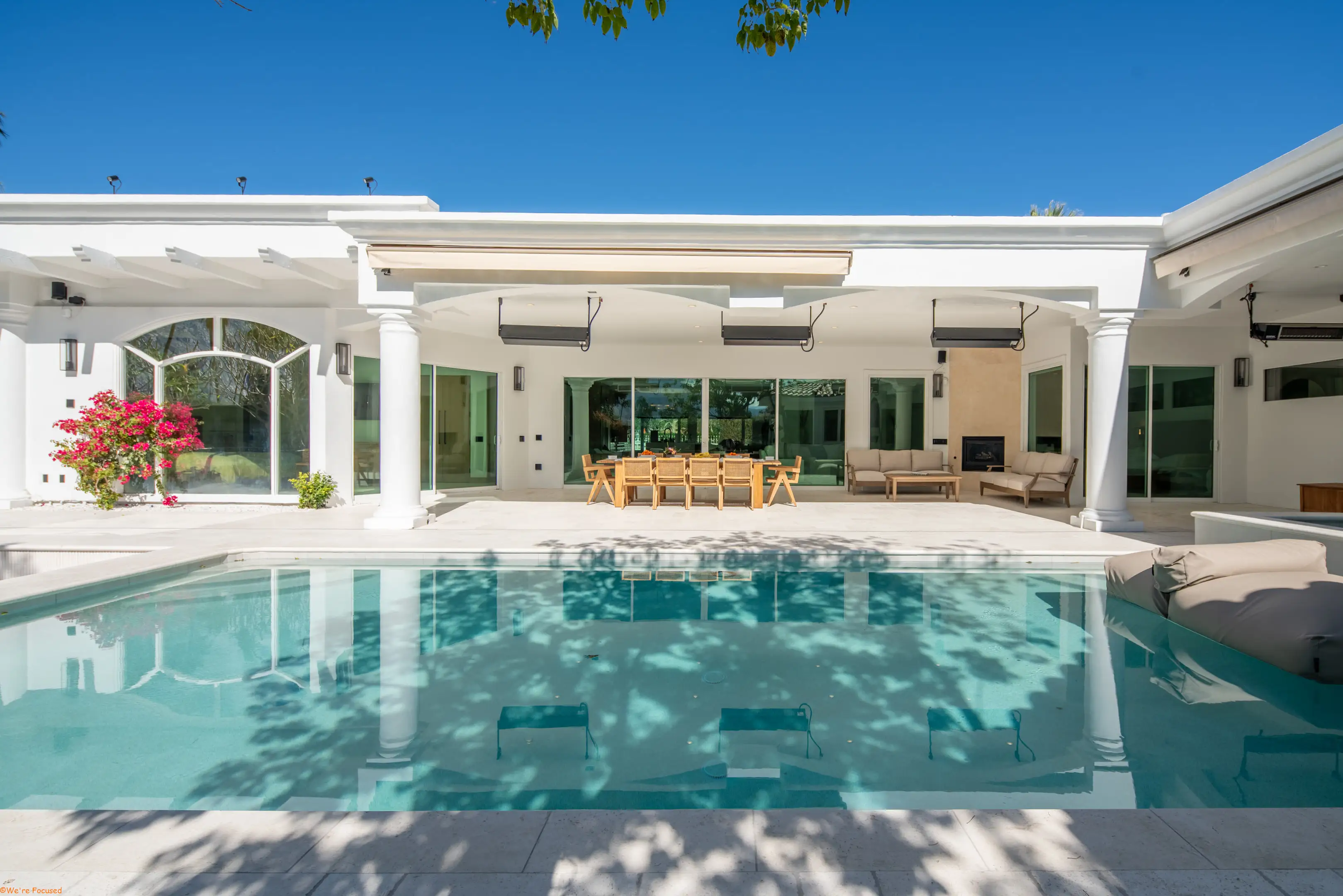 The length of the pool with the covered terrace and the house behind it.