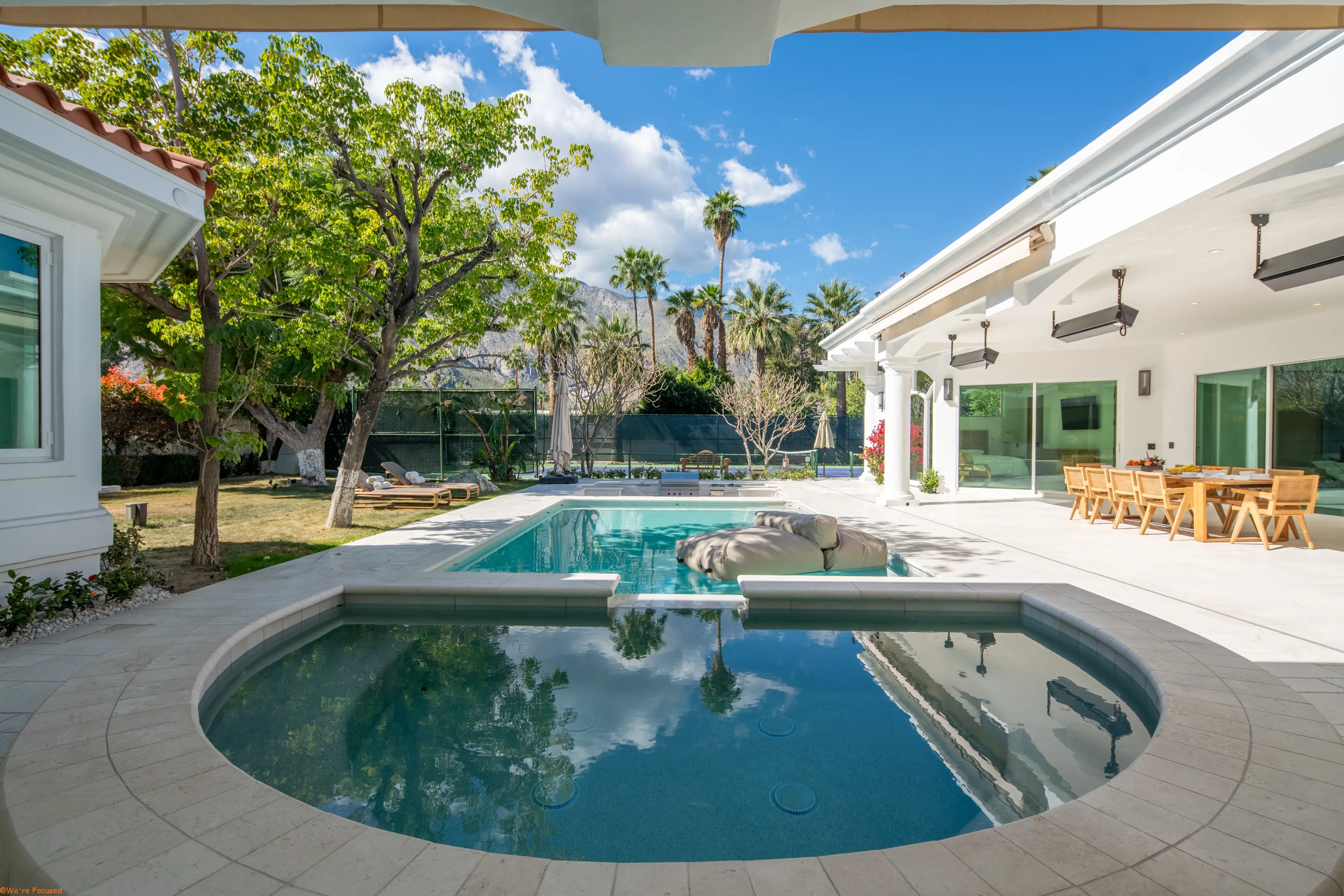 The pool and spa in the courtyard with the house and its colonnade behind.